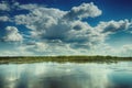 Large beautiful cumulus clouds in the afternoon over a silver ri Royalty Free Stock Photo