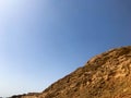 A large beautiful majestic stone sandy mountain, a mound in the desert against a blue sky. Landscape