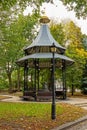Large beautiful metal gazebo with benches in a city garden or park