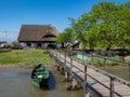 Large, beautiful, traditional, upstairs house in the Danube Delta with wooden pontoon and green anchored boat Royalty Free Stock Photo