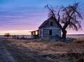 A large beautiful wooden two story abandoned farm house with peeling paint and broken windows in a rural summer Royalty Free Stock Photo