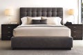 A large bed with a gray headboard and a white comforter Royalty Free Stock Photo