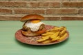 large beef burger with melted cheese, fried egg, tomato and bacon with