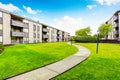 Large beige apartment building with three floors and balconies. Well kept lawn Royalty Free Stock Photo