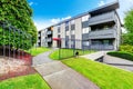 Large beige apartment building with three floors and balconies. Well kept lawn Royalty Free Stock Photo