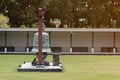 A large bell is set in the middle of the lawn in the temple