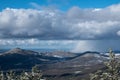 Large billow of dark clouds over fields and hills