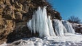 Large bizarre icicles hang from the slope of the granite rock.