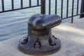 Large black bollard on a concrete dock