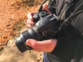 A large black modern digital mirror professional camera in the hands of the photographer. A man photographer adjusts a camera Royalty Free Stock Photo