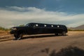 Large black stretch limousine on a tire jack on the side of a road Royalty Free Stock Photo