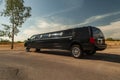 Large black stretch limousine on a tire jack on the side of a road Royalty Free Stock Photo