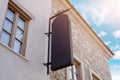 Large black vertical sign on the street facade