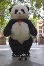 A large black and white panda doll and a small panda toy with a jar to collect money.