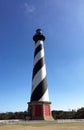 Large black and white striped lighthouse against a blue sky Royalty Free Stock Photo
