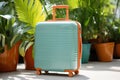 A large blue beautiful travel suitcase on the background of exotic plants. The concept of a vacation to the southern regions