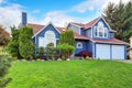 Large blue house with white trim and a nice lawn.