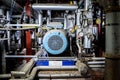 Large blue metal electric water pump turbine motor in industrial power station setting surrounded by steel pipes pressure gauges Royalty Free Stock Photo