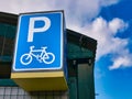 A large blue sign with white graphics marks a secure cycle lockup facility at a local railway station.