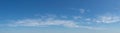 Large blue sky panorama with wispy white clouds