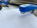 A large blue stapler for stapling paper lies next to the folders of documents on the working business desk in the office. Royalty Free Stock Photo