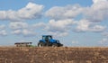 A large blue tractor, plowing field against the beautiful sky Royalty Free Stock Photo