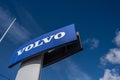 Large blue Volvo sign on a tall grey pylon..