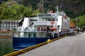 Large blue-and-white ship moored in the harbor of the village of Flam Norway