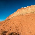 Large Boulder Below the Steep Cliffs of the Waterpocket Fold Royalty Free Stock Photo