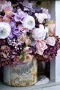 A large bouquet of artificial flowers in a metal jar. Floristic design in Provence style.