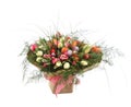 A large bouquet of color tulips in a square vase.