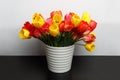 Large bouquet of yellow and red tulips in a large white vase is on the table Royalty Free Stock Photo