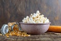 A large bowl of popcorn, corn grains and corncob on a wooden table Royalty Free Stock Photo