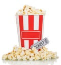 Large box full popcorn and popcorn around movie ticket on white. Royalty Free Stock Photo