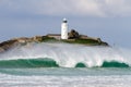 Large wave breaking in front of lighthouse Royalty Free Stock Photo