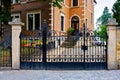 Large brick building with black iron gate and clock on the front of it in Germany. Royalty Free Stock Photo