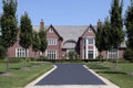 Large brick home with row of trees Royalty Free Stock Photo