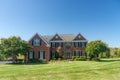 Large brick house with a green lawn. Landscape on a summer sunny day