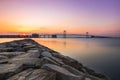 Large bridge crossing still body of water, reflections in the water. Throggs Neck Bridge, Queens New York