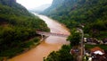 A large bridge divides the dark brown river