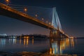 Large bridge illuminated over water at night Royalty Free Stock Photo