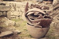 Large broken clay pots stand on the ground .toned