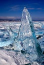 A large broken transparent piece of ice stands frozen vertically on Lake Baikal. Royalty Free Stock Photo