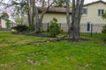 A large broken tree branch laying on the grass near a house.