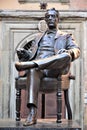 Large bronze statue of Giacomo Puccini sitting comfortably with a cigar in his hand in Lucca in the square near his birthplace.