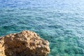 Large brown beautiful stone, a rock in the sea against a background of blue water and copy space. The background. Royalty Free Stock Photo