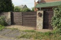 Large brown closed wooden gate and door on a gray stone wall Royalty Free Stock Photo