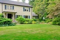 Large brown house exterior with summer garden.