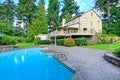 Large brown house exterior with summer garden and swimming pool