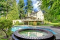 Large brown house exterior with summer garden with pool. Royalty Free Stock Photo